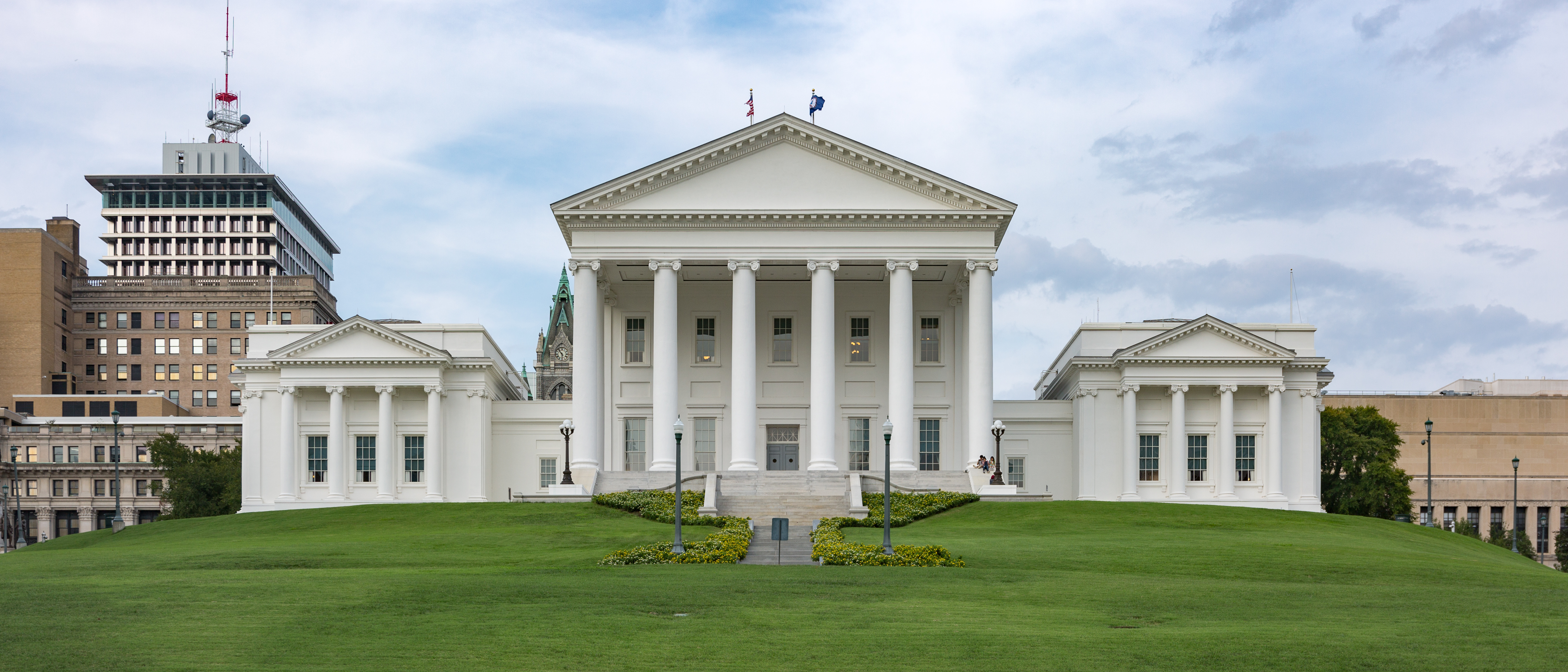 Virginia State Capitol building with white columns and neoclassical architecture on green lawn