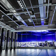Modern data center with server racks, purple LED lighting, and nighttime city skyline visible through windows