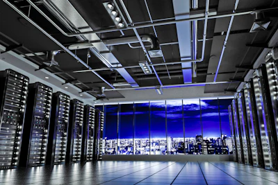 Modern data center with server racks, purple LED lighting, and nighttime city skyline visible through windows
