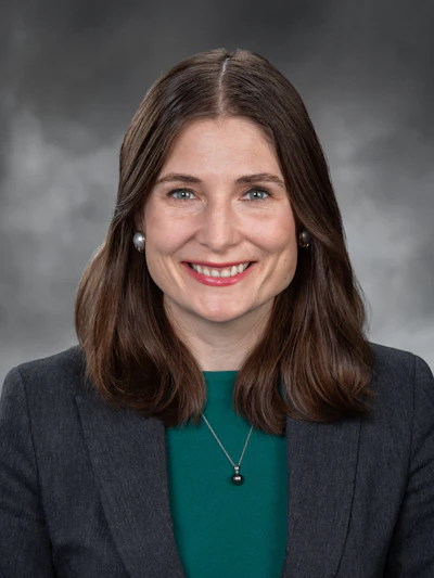 Professional headshot of a woman in business attire smiling at the camera
