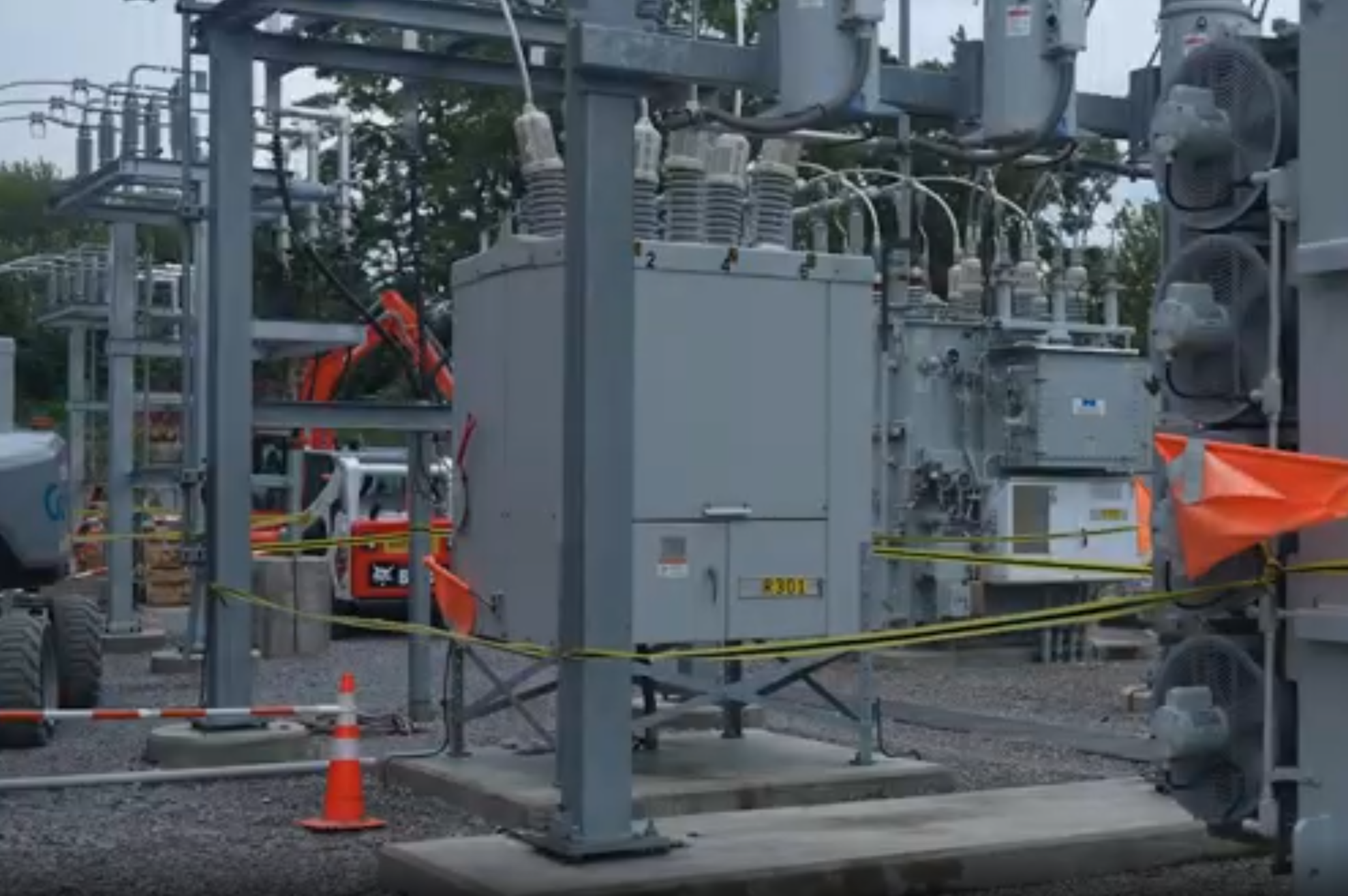 Industrial electrical substation with large transformers, safety barriers, and equipment under maintenance